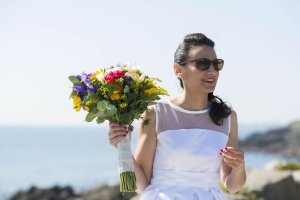 Marié en robe avec son bouquet de fleurs