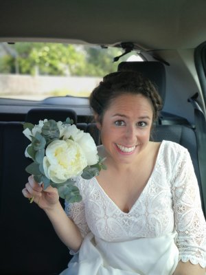 La mariée et son bouquet dans une voiture