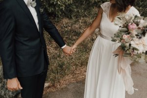 Buste de la robe de mariée, les mariés se tiennent la main.